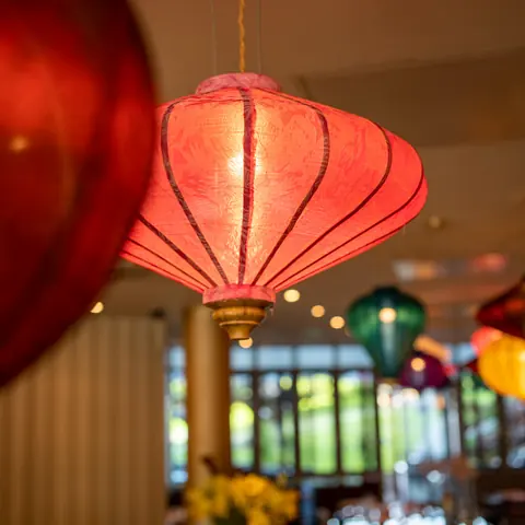 Rote und bunte Seidenlampions dicht unter der Decke