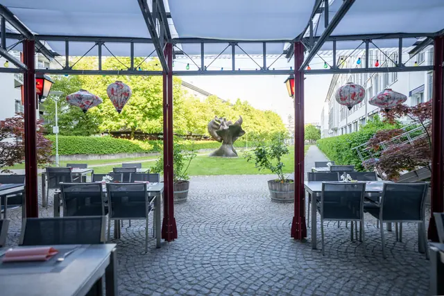 Überdachte Terrasse von Yee Chino mit Blick auf die Rasenfläche
