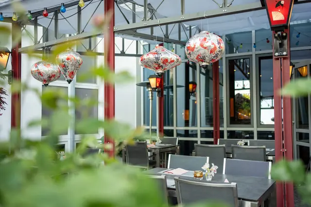 Terrasse mit roten Säulen und gemusterten Lampions